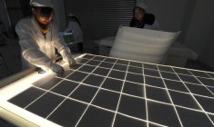 Des employés travaillent sur une ligne de production de panneaux solaires dans l'atelier d'une société solaire à Hefei