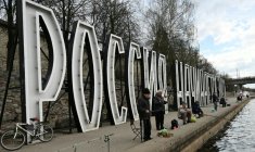Des pêcheurs devant des lettres géantes "La Russie commence ici" sur la rivière Velikaïa à Pskov, le 17 avril 2026 en Russie (  / Olga MALTSEVA )
